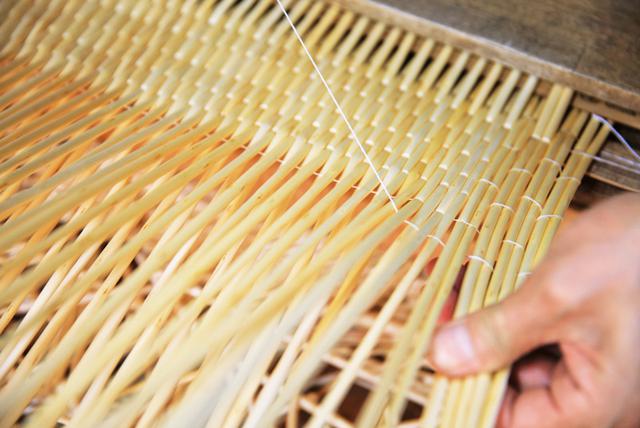 画像: 柳のしなりを利用して、間に麻糸を通し、固く編み締めていくのが杞柳細工の特徴。中央から外側に向かって編み、板状に仕立てていく