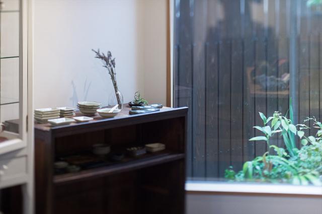 画像: 店内にある古家具はどれも、小池さん夫妻がご自宅で使っていたもの。窓からは山里をイメージしたという植栽が顔を覗かせ、心地いい空間に