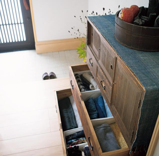 画像: 出かけるときにさっと出せるよう、ストール類は玄関の引き出しに。中を紙箱やブックエンドで区切って
