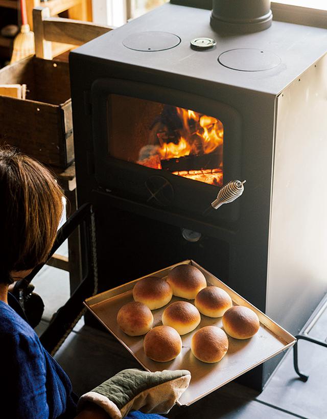 画像: 薪ストーブは、パンを焼きたくてオーブン調理もできるものに。温度や時間など、コツをつかむまでは多少苦労したものの、昨冬はさまざまなパンづくりに挑戦し、何日も続けてピザを焼くこともあったのだとか。焼き上がった丸パンはふっくらもちもち。パンを焼いている間の甘い香りもごちそうです
