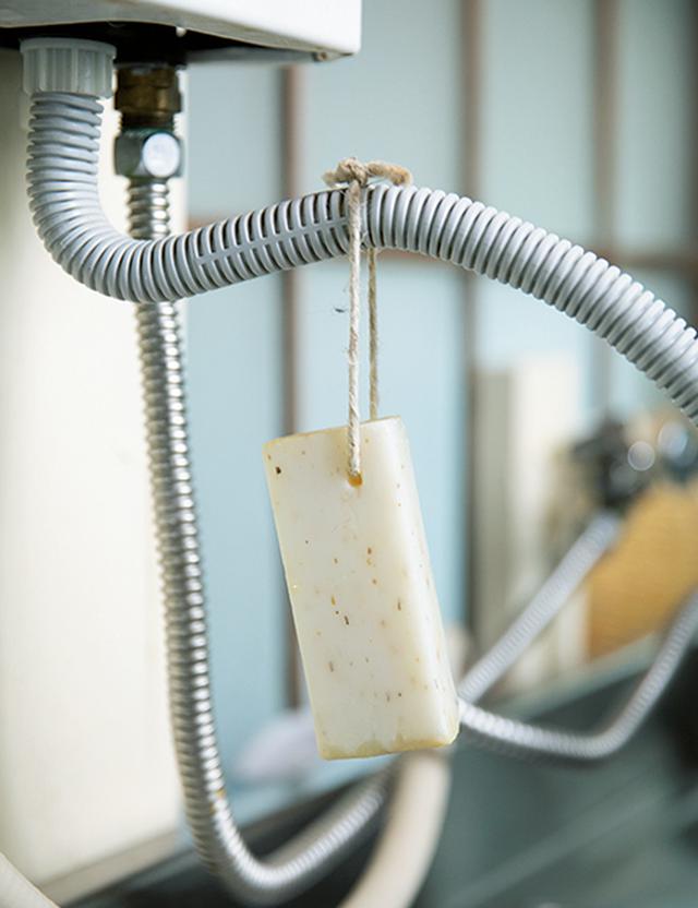 画像: 石けんは湯沸かし器に吊るして。「平置きにすると周りに水がたまったりヌメリができたりするので、これが一番衛生的」