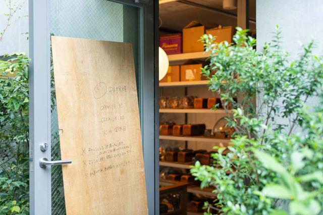 画像: コンクリート打ち放しの壁に、べニア板一枚の手描き看板が味わいを添えています