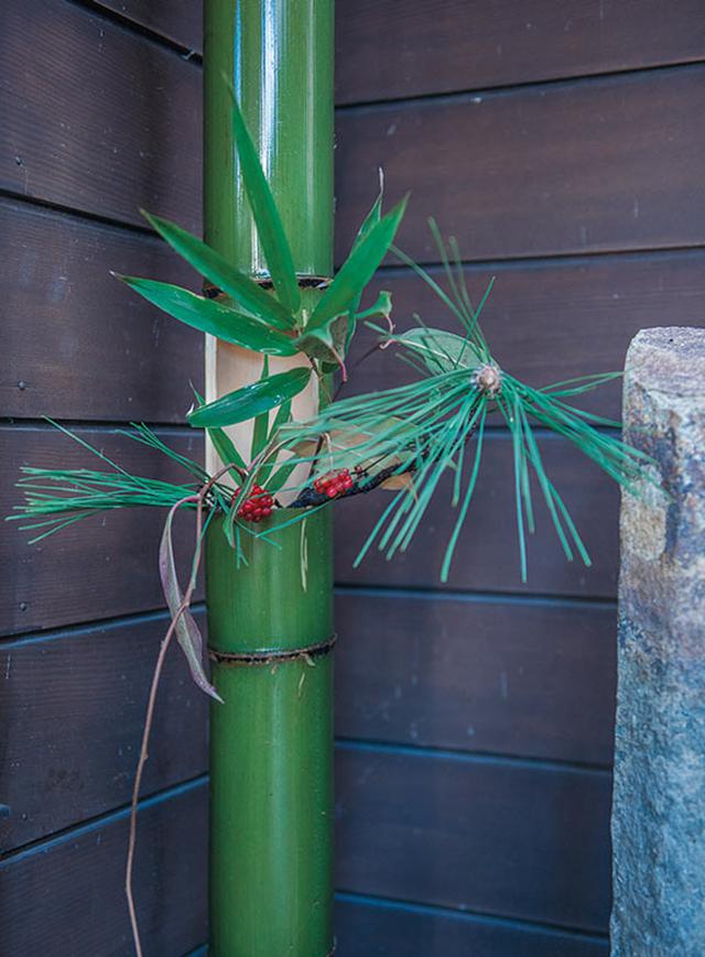 画像: 青竹に菜種油をぬってつやを出し、笹や松、南天を飾って玄関に