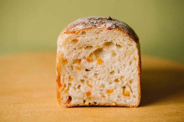 画像: 「フランス食パン」がまだなかった頃、高齢のお客さんから「私でも食べられる柔らかいパンをつくってほしい」とリクエストされて考案した「オレンジフランス」。しっとり柔らかな生地に、爽やかな伊予柑ピール入り