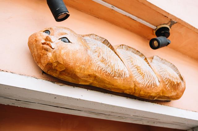 画像: 木彫りのフランスパンがお出迎え。店のシンボルにと、知り合いの木彫り作家さんにお願いしてつくってもらったもの