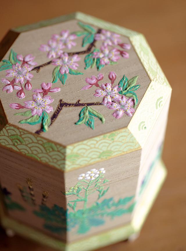 画像: 合わせ貝をしまうための「貝桶」といわれる作品。彩色が難しい桐の箱全体に、桜やなずな、つくしなど春の草花が可憐に描かれている