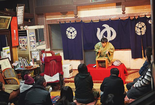 画像: 休業日の銭湯で、脱衣所を使っての定例落語会が開かれた。太遊さんの高座を、錦市場の人や銭湯の常連、ファンの人たちが見にきた