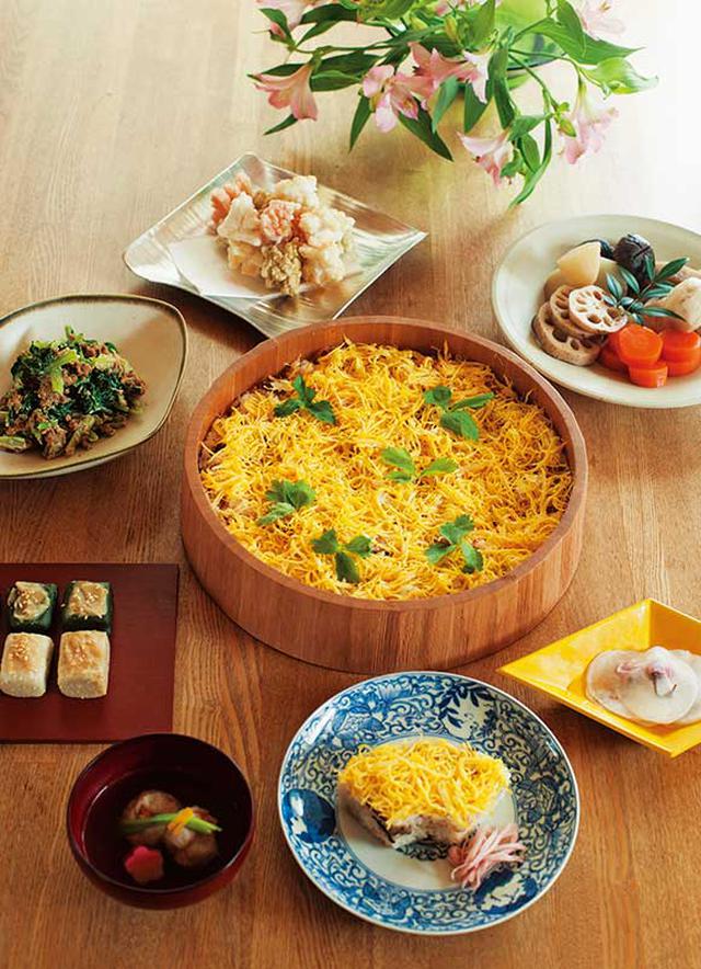 画像: テーブルいっぱいに並んだ、ごちそう。染付や漆など、食器も、お祝いの食卓を意識して選ぶ。娘さん用のちらし寿司は、松の型抜きを使って特別感を