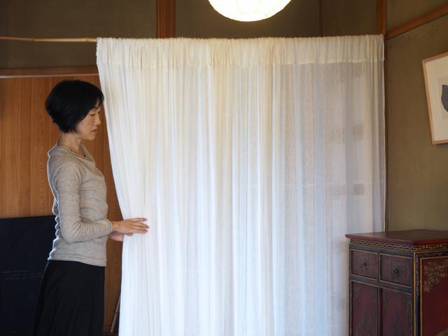 画像: 玄関ホールでは、竹竿に通した綿布をパーティションに。ほんのり向こう側が透けるので、空間が重くなりません