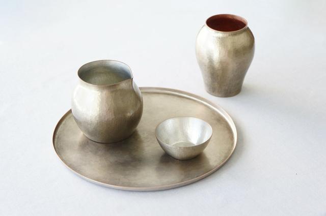 画像: 新潟県の伝統工芸、鎚起銅器の作品。手前が盆、片口、猪口、奥は一輪挿し。鎚起銅器は経年変化が楽しめ、使うほどに色に深みが増します