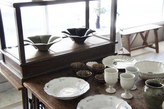 画像: 手前の染付は志村和晃さん、奥の花型の鉢は宮田竜司さんの作品。棚やテーブルは、お隣の新発田市にある古道具屋さん「古道具ハチミツ」で揃えたものが多いそう