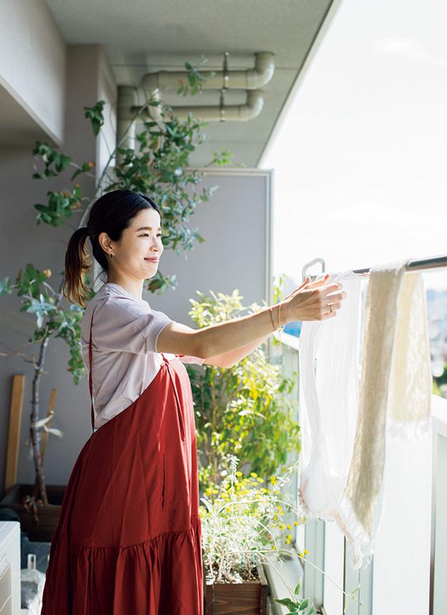 画像: 南向きのベランダで、洗濯したタオル類を干す清水さん。「干すときに洗濯物を伸ばしたり、パンパンと叩かなくても、ふんわり仕上がりますよ」