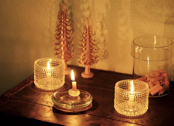 画像: 煤が出ないみつろうキャンドルと、光の反射が美しいガラスのホルダーを。形のかわいい雑貨をそばに置き、壁に映る影も楽しむ