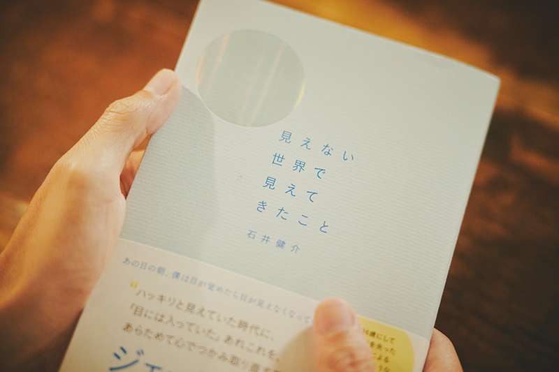 画像: 著書の表紙には満月のように青く光る箔押しが。「この加工のおかげで、本棚で手に取ると自分の本だとわかります」