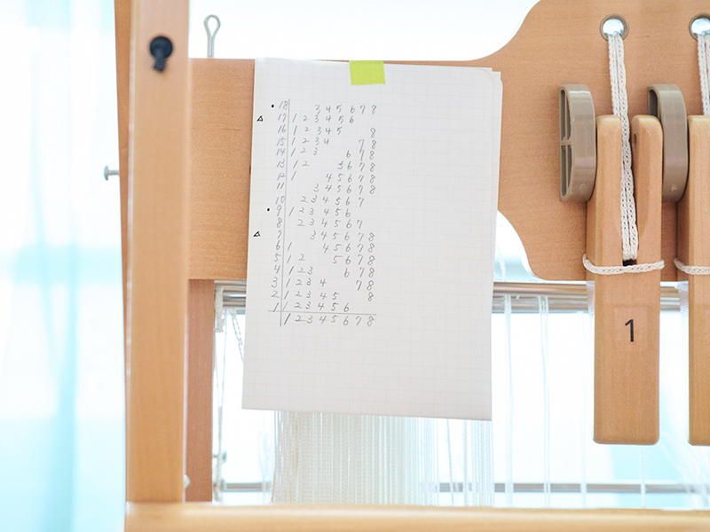 画像: 考えた織り図をもとに、8つのレバーと筬(おさ)を動かしながら織っていく