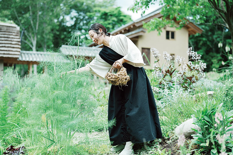 画像: 草花と戯れるように、庭の手入れを楽しむ愛さん。「植物の元気な姿を見て、日々喜びを感じています」。休日は家族で山道を散歩しながら、植物探索をしているそう。