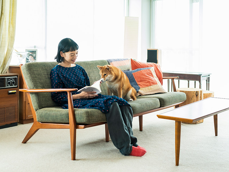 画像: リビングのソファが本を読むときの定位置。読書中、愛犬の椿がかたわらに座ることもしばしば。夫も本好きで、夫婦で面白かった本を薦め合うことも多い