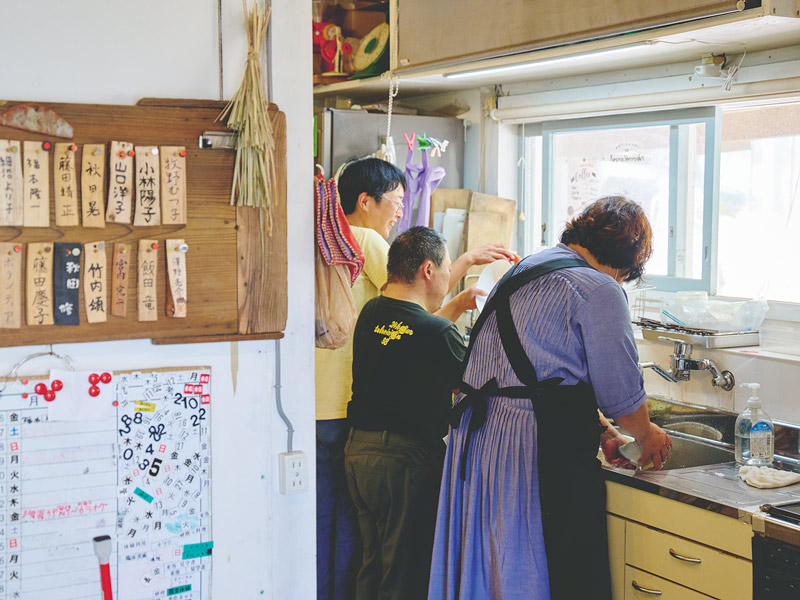 画像: 母屋の台所。窓の設置されたこの壁面、実は、リフォームの際に一度すべて取り壊され、通りから室内が丸見えになっていた時期も