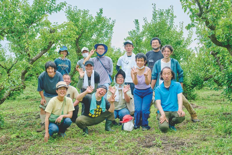 画像: 汗をふきふき、「にこにこ農園」での作業を終えて。園主の井上さん（後列右から2人目）は、藤沢市の養護学校の元教員
