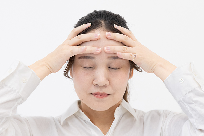 画像: 眉が上がらないように、指でおでこを押さえる