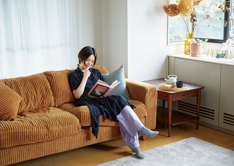 画像: 「じっくり本を読めるように」と選んだ、ずっしりとした心地よいソファで読書。「ここに寝そべって、何時間も読むことがあります」