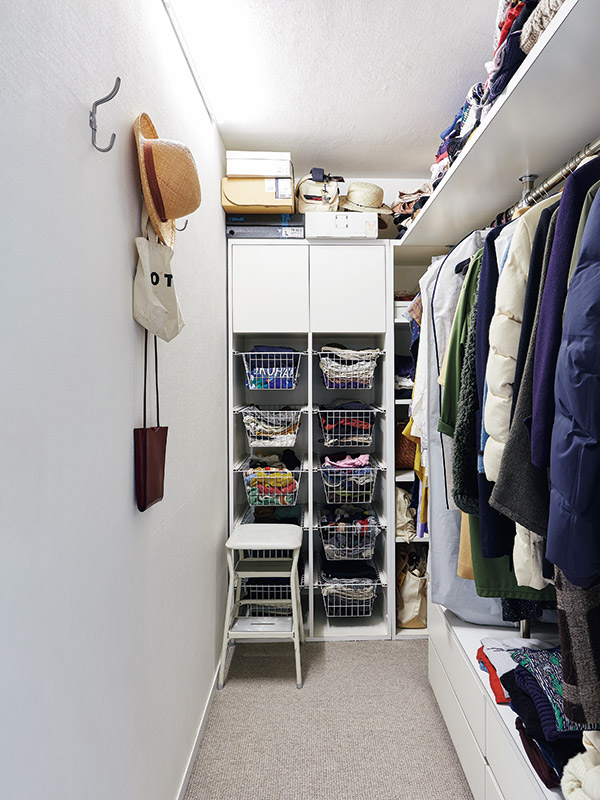 画像: ウォークインクローゼットに置いてある踏み台を使って、上の棚にある服をこまめにチェック。季節ごとのまとまった衣替えはせず、気分に合わせて服の位置を入れ替えている