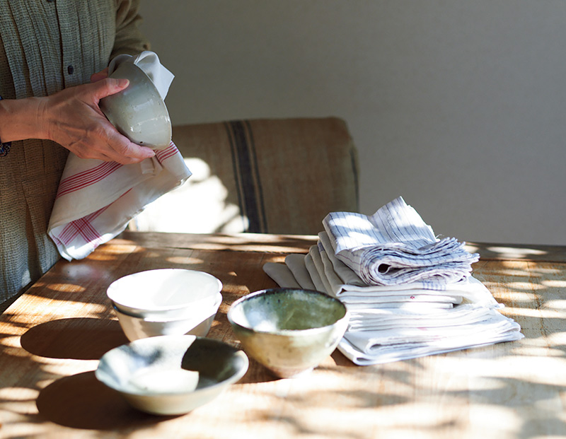 画像: 洗い終えた食器は、毛羽立ちにくいアンティークのリネンでふく。ざるも食器も毎日使うことで、風合いが増し、美しさを保てる