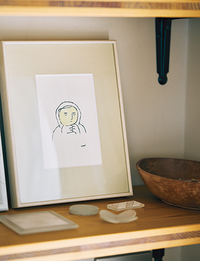 画像: 少しだけ飾るところを、とリビングルームに棚をつくった。友人の川原真由美さんの絵や、庭で摘んだ花などを飾っている