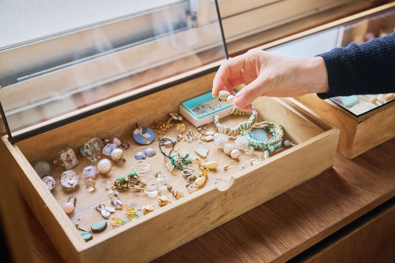 画像: アクセサリー類はガラスケースにひとつひとつ並べて収納。「ときどき場所を入れ替えて楽しんでいます」と井上さん