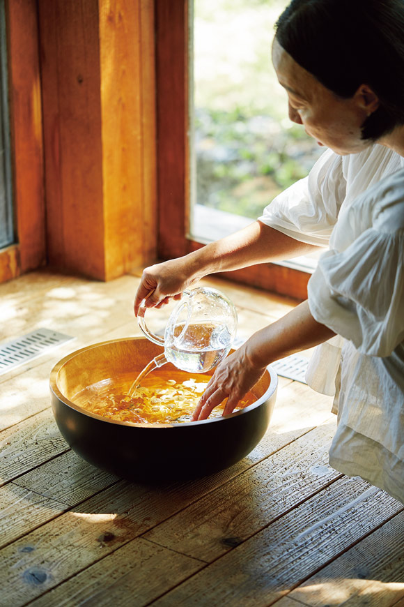 画像: たらいにドライハーブを入れて熱湯を注ぎ、成分や香りを抽出する。その後水を加えて適温に