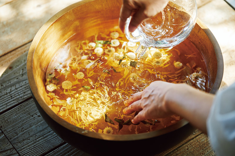 画像: ドライハーブをたらいに入れ、お湯を注いで足湯の準備。ハーブのいい香りが部屋に漂い、心身をほぐしてくれる