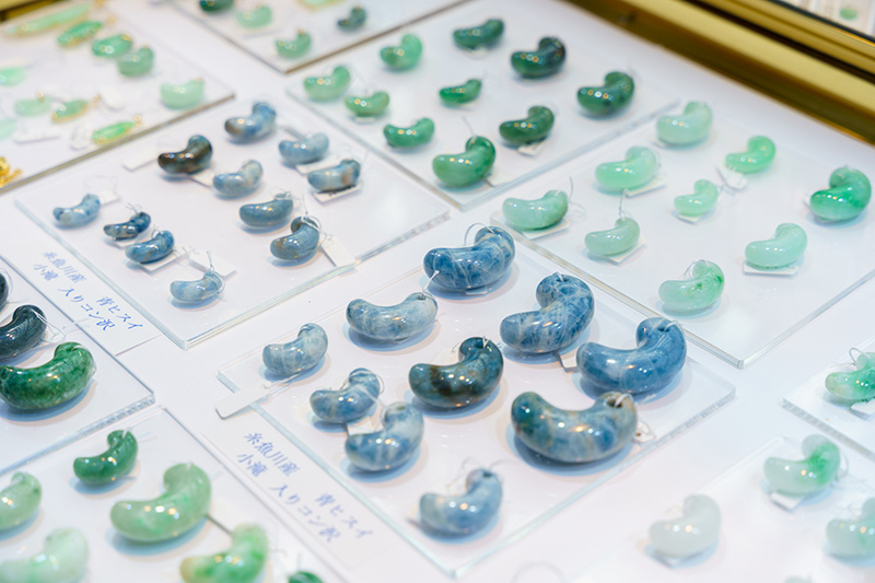 画像: 「東京国際ミネラル秋のフェア IMAGE2025」で売られていた青翡翠の勾玉。大きいもので4cmほどもあったような? 希少な品らしく、立派なガラスケースに収められていました