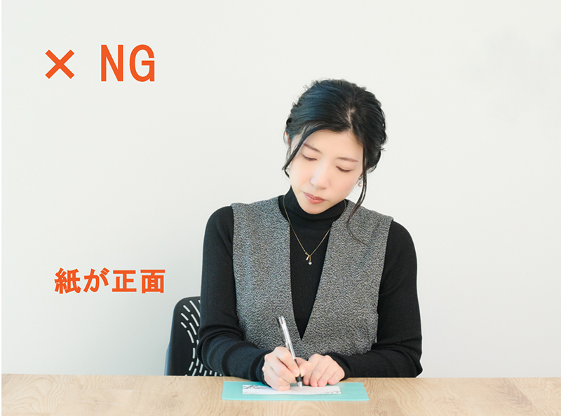 画像: NG例 体の正面に紙を置く