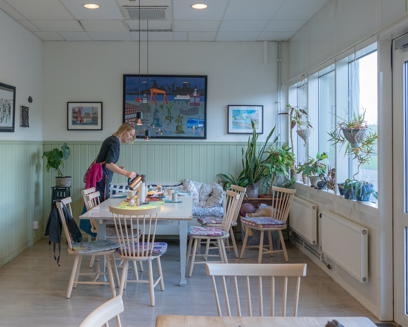 画像: 眺めの良いランチルームでフィーカの準備をする支援員のマリアさん