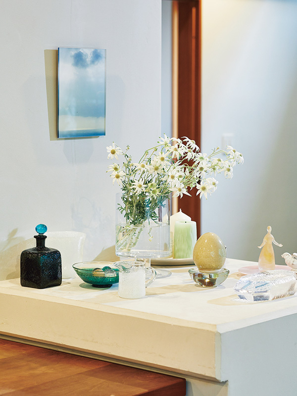 画像: 家の中心にある暖炉の上が、引田さんいわく「わが家の神聖な場所」。季節の花を飾り、周りに空間を浄化してくれそうな石やオブジェを置いている