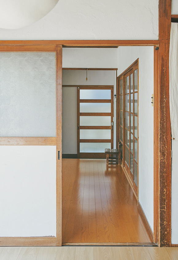 画像: リビングから玄関を眺めました。扉は木とガラス、壁は漆喰。ちなみに右側は仕事部屋です