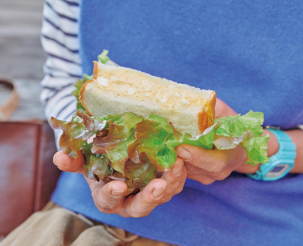 画像: パン屋さんで買ったサンドイッチを、持参のサニーレタスでくるんで、大胆に野菜のボリュームアップ