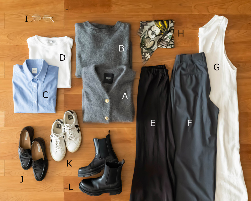 画像: A. グレーアンゴラVネックカーディガン B. グレークルーネックニット C. ブルーシャツ D. ホワイトクルーネックカットソー E. ブラウンマーメイドスカート F. グレータックパンツ G. ホワイトジャンパースカート H. スカーフ I. ゴールドフレームメガネ J. ブラック型押しローファー K. ホワイトのレザースニーカー L. サイドゴアブーツ
