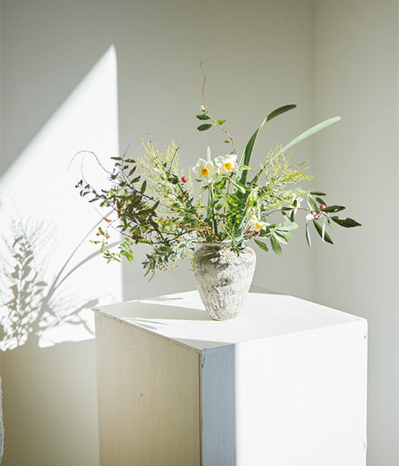 画像: 玄関の白い花台に、庭の草花を活けて。「この花台は部屋の中でも季節が楽しめるように、高さを考えながら私がDIYしました」
