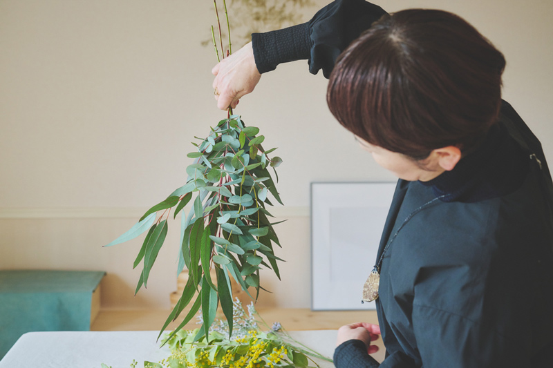 画像: 手を持ち替えて逆さに。スカスカな部分があれば、切り落とした枝など余っているユーカリを足す。その際は、握ったまま上から差し込めばOK