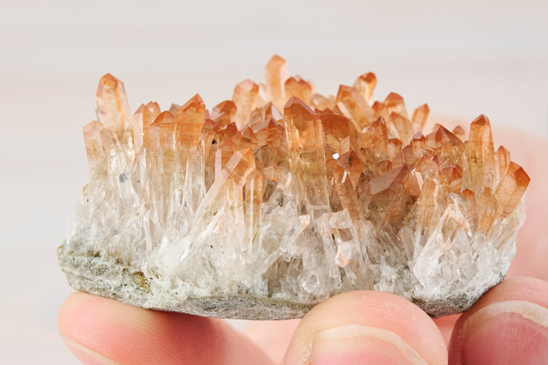 画像: 先端が赤くなっている水晶のクラスター。大きくはないですが、近くで見ると迫力があります