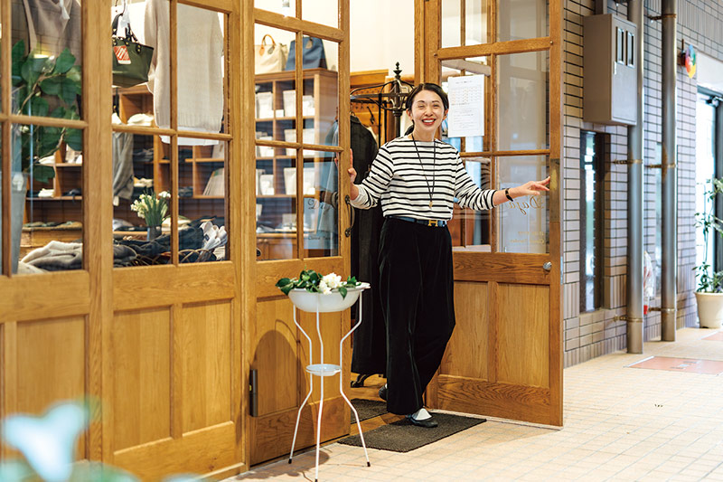 画像: 天井まであるオリジナルの木戸がダジャの目じるし。入り口には花台を置き、季節の草花とともに訪れる人をお出迎え。「できるだけ園芸植物ではなく、島根の野の花を飾るのが小さなこだわりです」