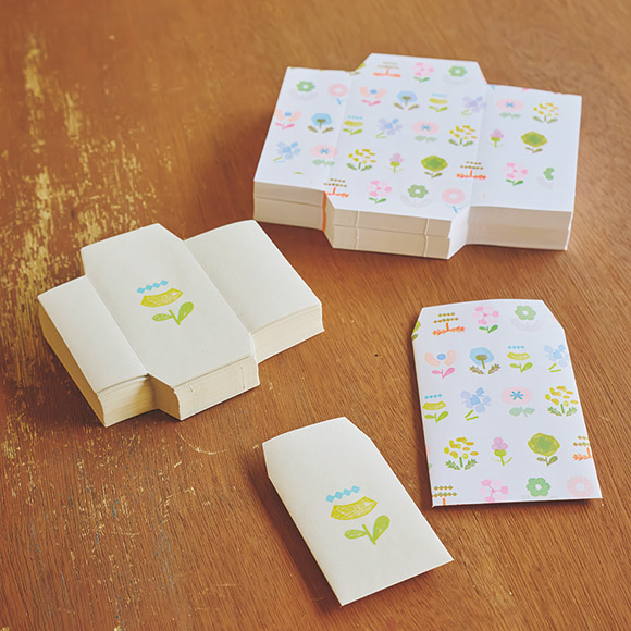 画像: 植物モチーフのポチ袋とペーパーバッグ。折り線が入っているが、紙が薄いため、折る作業は繊細さを要する。機械プリントだが、ひとつずつハンコを押したようなかすれ具合が独特の存在感