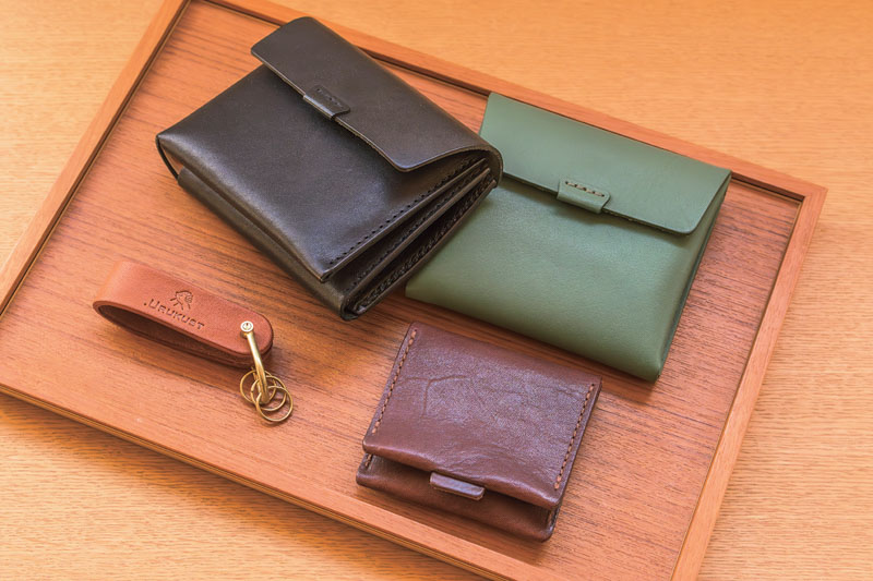 画像: 「ウルクスト」の財布、コインケース、キーホルダー。定番色は落ち着いたカラーだが、毎年11月ごろに発売する限定色は明るい色を選ぶことが多い。グリーンは2024年の限定色