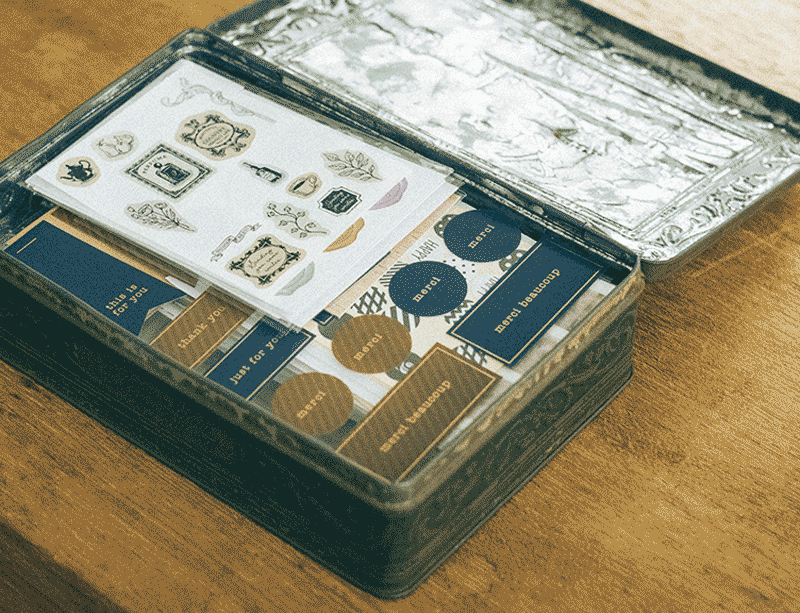 画像: シールやマスキングテープはお気に入りの缶や箱にまとめておくと、机の上に持ってきて作業がしやすい