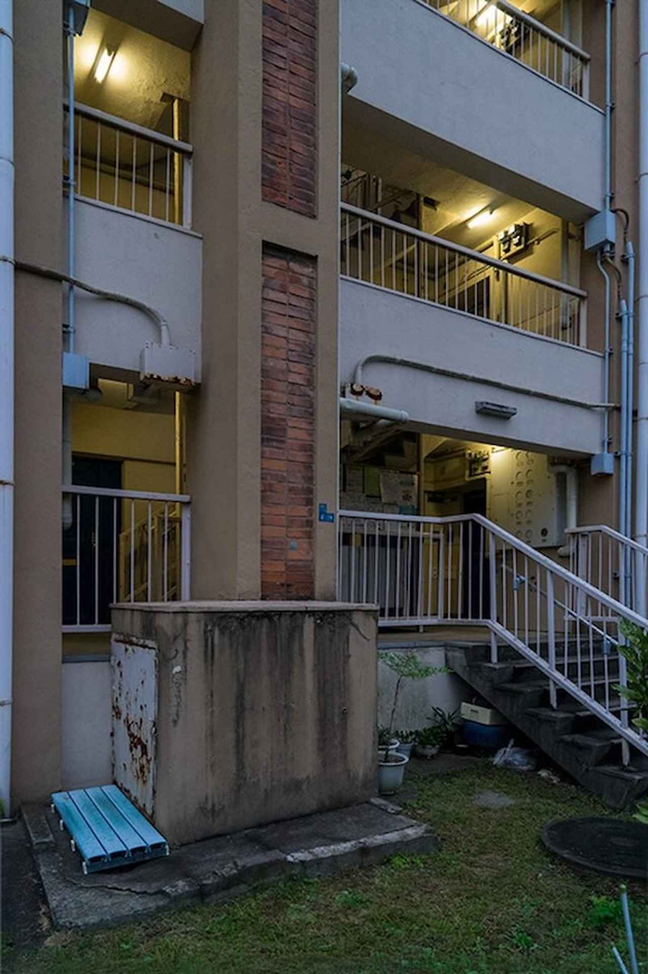 画像: 赤羽台団地に備えられていたレンガ張りのダストシュート。当時は近代的な暮らしを象徴する設備だったと思います。ダストシュートが設けられたものの使用を停止している古い団地も数多く見てきましたが、取り出し口の樹脂製のすのこを見ると、この住棟（39号棟）では使用され続けられていたようです