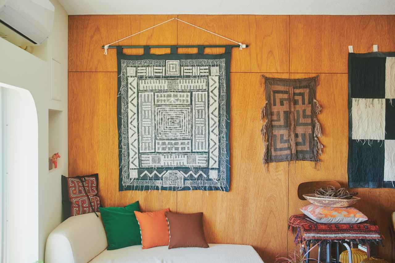 画像: 合板が貼られた温かみのある壁。壁にかかるタペストリーは、タシロさんの作品