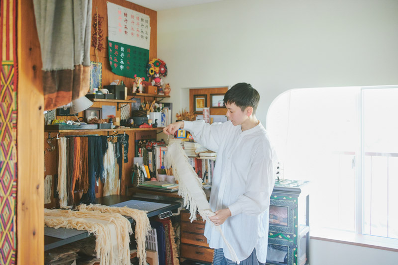 画像: ゆるく仕切られた一室をアトリエに。前に吊るされている糸は、ベンガラや化学染料で手染めしたもの