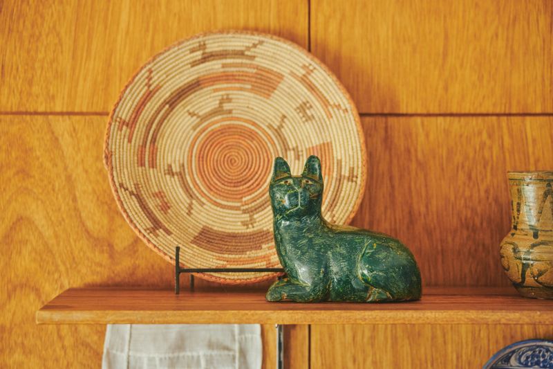 画像: 茶系の壁とプレートに、猫のオブジェのグリーンが映える