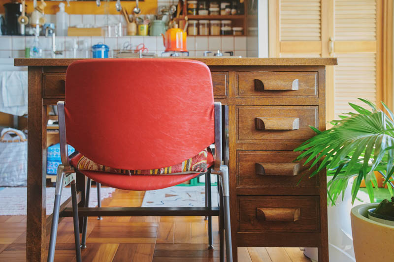 画像: 古道具屋で手に入れた趣のあるデスク。赤い椅子はヴィンテージで、イタリアの「カステリチェア」